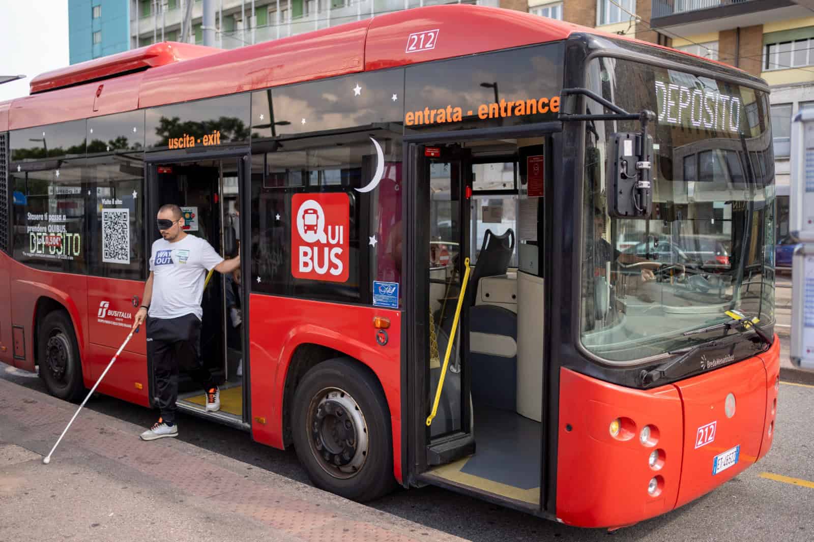 Formazione esperienziale del progetto sensoriAbile anch'io per i futuri autisti di Bus Italia Veneto.
La scena si svolge lungo una pensilina degli autobus in piazzale Stazione a Padova.
Un autista in formazione bendato con una mascherina nera scende dal pullman con il bastone bianco cercando i logges a terra.